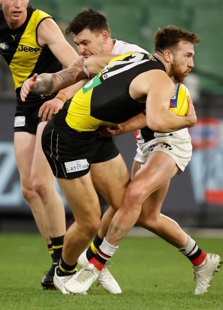 Noah Balta of the Tigers is tackled by Josh Battle of the Saints during the 2021 AFL Round 15 match between the Richmond Tigers and the St Kilda...