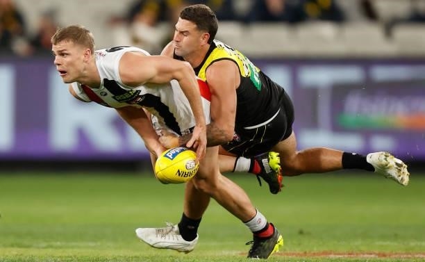 Mason Wood of the Saints is tackled by Jack Graham of the Tigers during the 2021 AFL Round 15 match between the Richmond Tigers and the St Kilda...