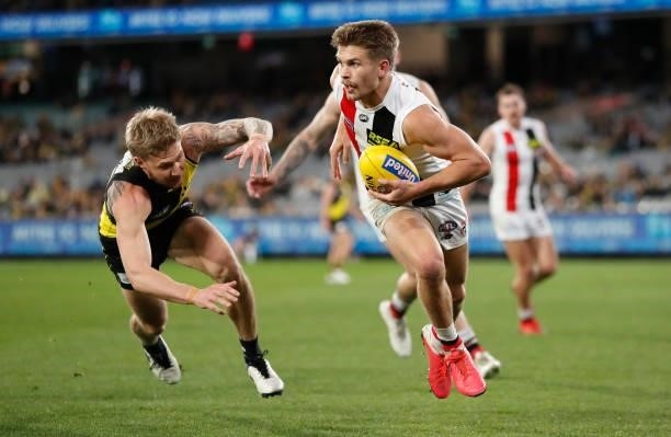 Dan Butler of the Saints is chased by Nathan Broad of the Tigers during the 2021 AFL Round 15 match between the Richmond Tigers and the St Kilda...