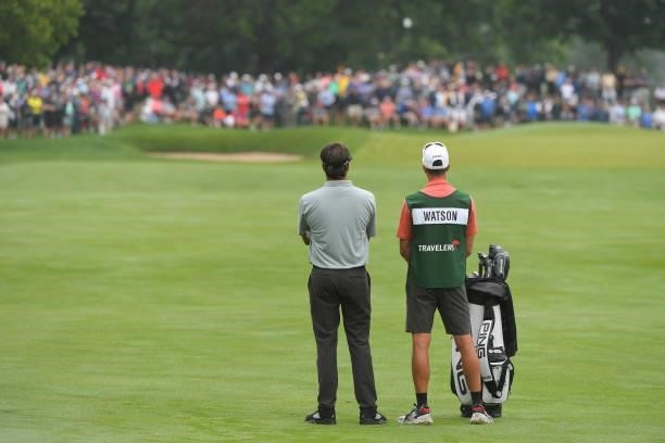 Bubba Watson and his caddie stand together on the fourth fairway during the second round of the Travelers Championship at TPC River Highlands on June...