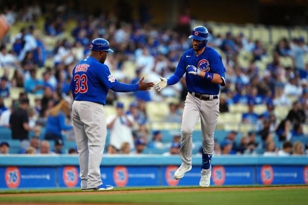 Third base coach Willie Harris of the Chicago Cubs celebrates with Kris Bryant after Bryant hit a home run during the game between the Chicago Cubs...