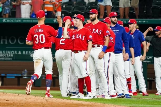 Brock Holt and Nate Lowe of the Texas Rangers high five after the game against the Kansas City Royals at Globe Life Field on June 25, 2021 in...