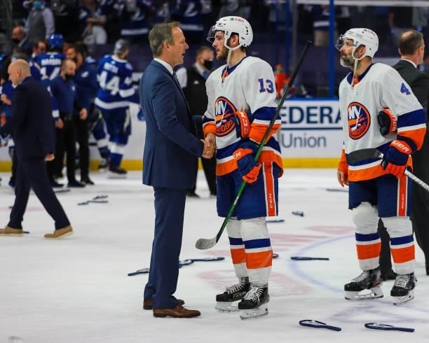Head Coach Jon Cooper of the Tampa Bay Lightning celebrates the game and series win and shakes hands with Mathew Barzal of the New York Islanders in...