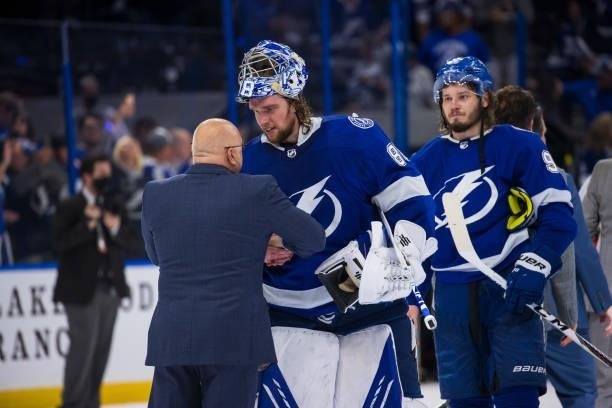 Goalie Andrei Vasilevskiy of the Tampa Bay Lightning shakes hands with Head Coach Barry Trotz of the New York Islanders after the series win in Game...