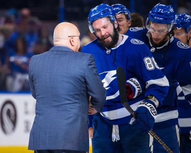 Nikita Kucherov of the Tampa Bay Lightning shakes hands with Head Coach Barry Trotz of the New York Islanders after the series win in Game Seven of...