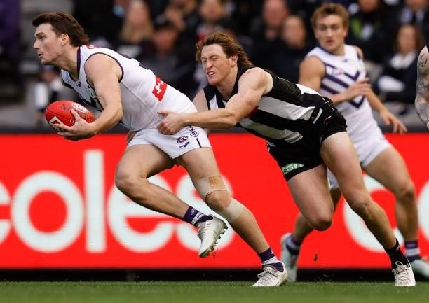 Blake Acres of the Dockers is tackled by Nathan Murphy of the Magpies during the 2021 AFL Round 15 match between the Collingwood Magpies and the...