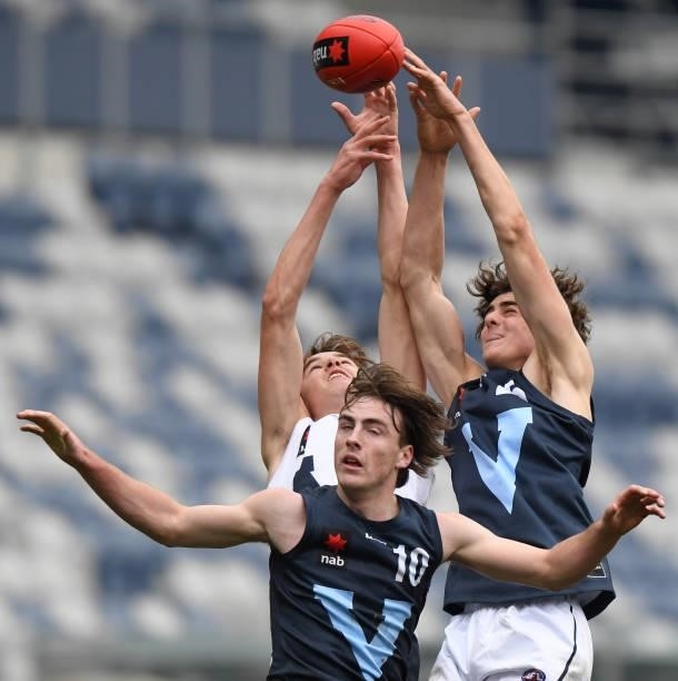 Aaron Cadman of Vic Country, George Wardlaw of Vic Metro and Dane Harvey of Vic Metro jump for the ball during the U17 Championships match between...