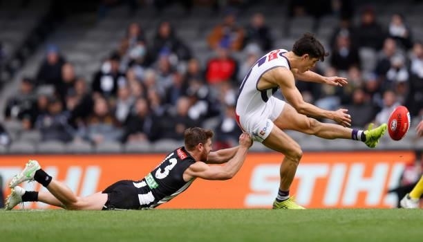 Adam Cerra of the Dockers is tackled by Taylor Adams of the Magpies during the 2021 AFL Round 15 match between the Collingwood Magpies and the...