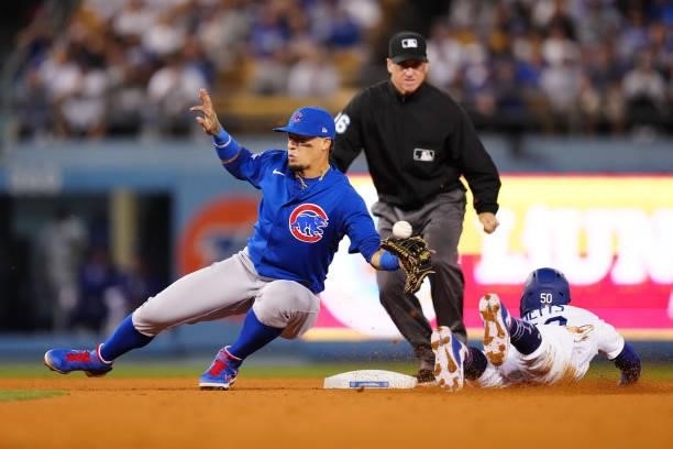 Javier Báez of the Chicago Cubs fails to catch the ball as Mookie Betts of the Los Angeles Dodgers steals second during the game between the Chicago...