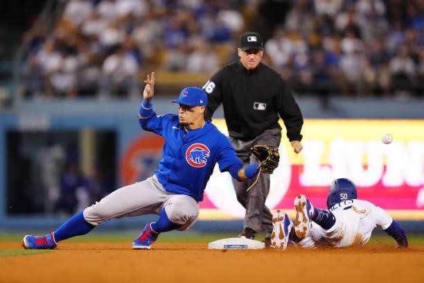 Javier Báez of the Chicago Cubs fails to catch the ball as Mookie Betts of the Los Angeles Dodgers steals second during the game between the Chicago...