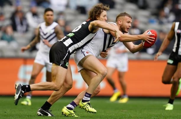 Brett Bewley of the Dockers is tackled by Chris Mayne of the Magpies during the 2021 AFL Round 15 match between the Collingwood Magpies and the...