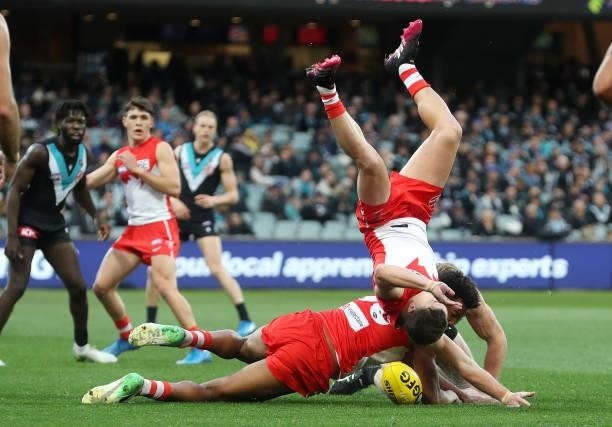 Tom Papley of the Swans crashes over /Joel Amartey of the Swans and Tom Jonas of the Power during the 2021 AFL Round 15 match between the Port...