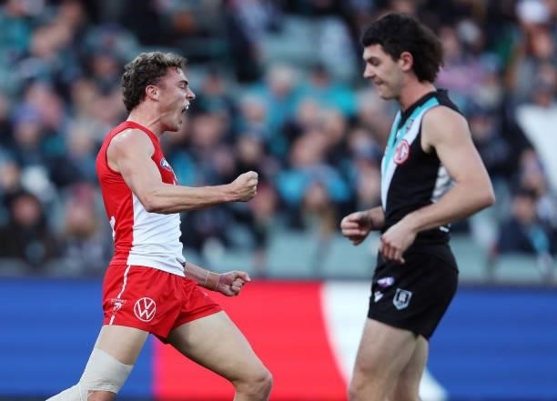 Will Hayward of the Swans celebrates a goal with Darcy Byrne-Jones of the Power walking past during the 2021 AFL Round 15 match between the Port...