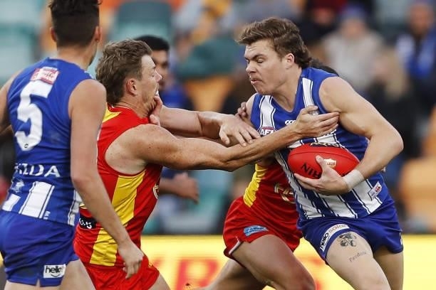 Cameron Zurhaar of the Kangaroos fends off Nick Holman of the Suns during the 2021 AFL Round 15 match between the North Melbourne Kangaroos and the...