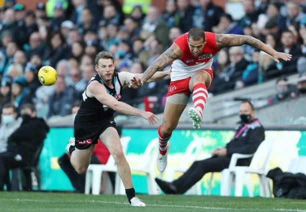 Lance Franklin of the Swans kicks the ball away from Trent McKenzie of the Power during the 2021 AFL Round 15 match between the Port Adelaide Power...