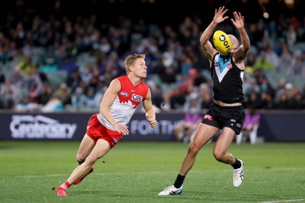 Isaac Heeney of the Swans tackles Jarrod Lienert of the Power during the 2021 AFL Round 15 match between the Port Adelaide Power and the Sydney Swans...