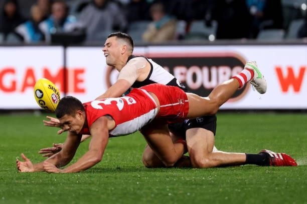 James Bell of the Swans clashes with Ryan Burton of the Power during the 2021 AFL Round 15 match between the Port Adelaide Power and the Sydney Swans...