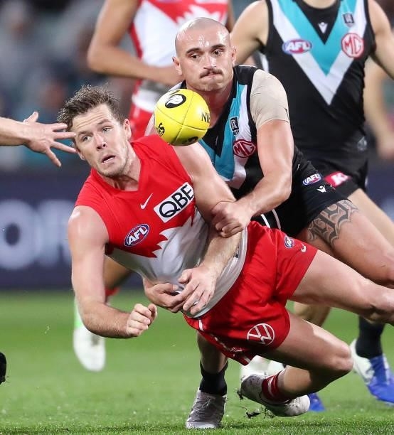 Luke Parker of the Swans handpasses the ball away from Sam Powell-Pepper of the Power during the 2021 AFL Round 15 match between the Port Adelaide...