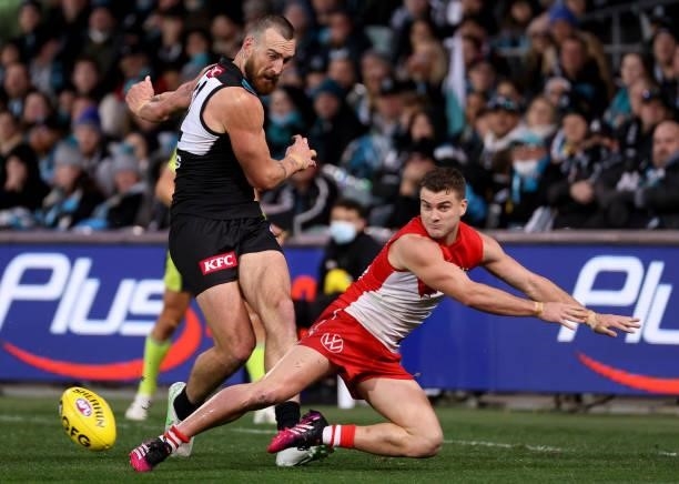 Charlie Dixon of the Power is tackled by Tom Papley of the Swans during the 2021 AFL Round 15 match between the Port Adelaide Power and the Sydney...