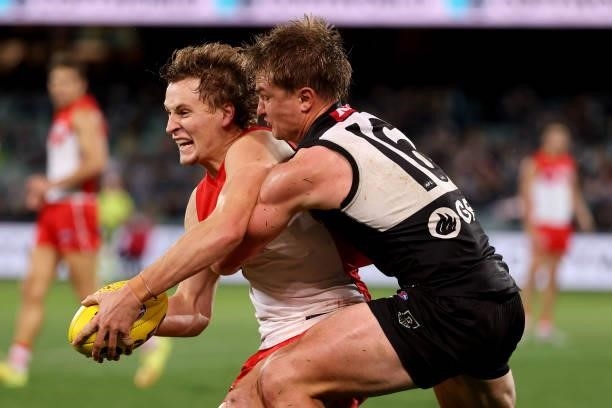 Jordan Dawson of the Swans,is tackled by Ollie Wines of the Power during the 2021 AFL Round 15 match between the Port Adelaide Power and the Sydney...