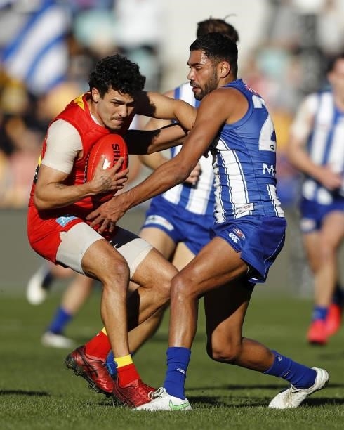 Izak Rankine of the Suns is tackled by Tarryn Thomas of the Kangaroos during the 2021 AFL Round 15 match between the North Melbourne Kangaroos and...