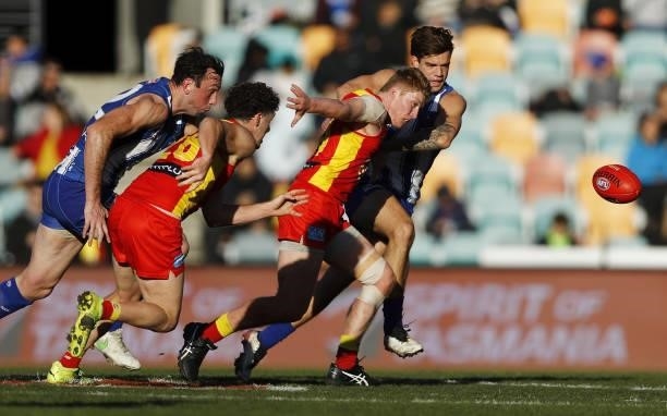 Todd Goldstein of the Kangaroos, Sam Flanders of the Suns, Matt Rowell of the Suns and Jy Simpkin of the Kangaroos compete for the ball during the...