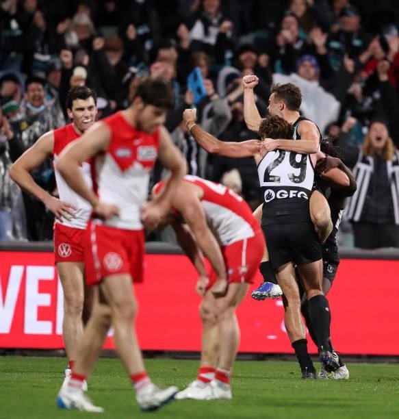 Scott Lycett of the Power celebrates a goal with team mates Karl Amon and Martin Frederick during the 2021 AFL Round 15 match between the Port...