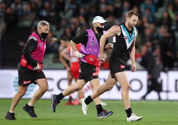 Trent McKenzie of the Power comes off with a shoulder injury during the 2021 AFL Round 15 match between the Port Adelaide Power and the Sydney Swans...