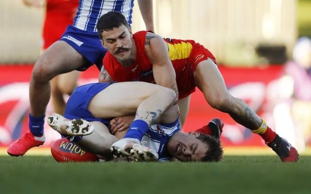 Cameron Zurhaar of the Kangaroos is tackled by Oleg Markov of the Suns during the 2021 AFL Round 15 match between the North Melbourne Kangaroos and...