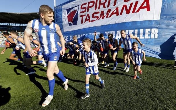 Jack Ziebell of the Kangaroos leads the team through the banner during the 2021 AFL Round 15 match between the North Melbourne Kangaroos and the Gold...
