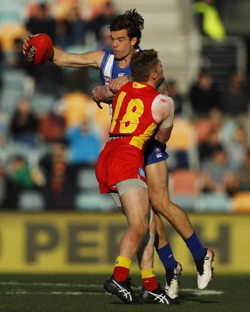Jy Simpkin of the Kangaroos is tackled by Matt Rowell of the Suns during the 2021 AFL Round 15 match between the North Melbourne Kangaroos and the...