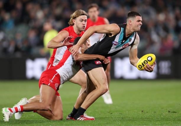 Ryan Burton of the Power tries to break the tackle of James Bell of the Swans during the 2021 AFL Round 15 match between the Port Adelaide Power and...