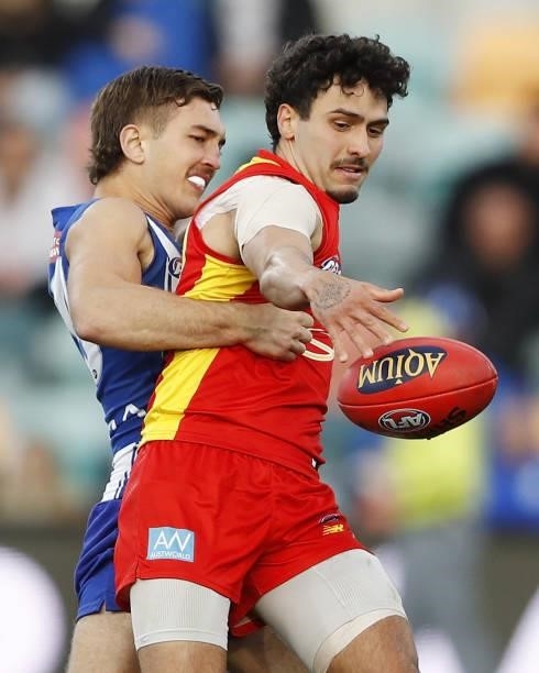 Izak Rankine of the Suns is tackled by Will Phillips of the Kangaroos during the 2021 AFL Round 15 match between the North Melbourne Kangaroos and...