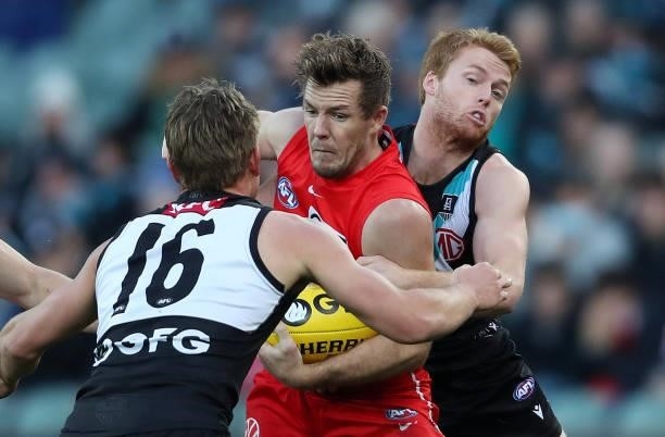 Luke Parker of the Swans under pressure from Ollie Wines of the Power and Willem Drew of the Power during the 2021 AFL Round 15 match between the...