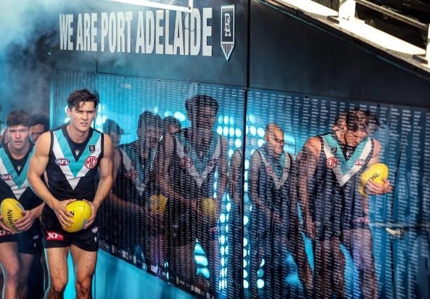 Port Adelaide about to enter the playing arena. Connor Rozee and Tom Jonas reflected in wall during the 2021 AFL Round 15 match between the Port...