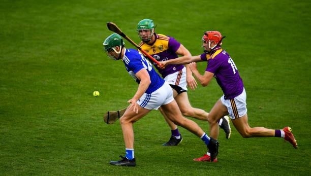 Kilkenny , Ireland - 26 June 2021; James Ryan of Laois in action against Matthew O'Hanlon, centre, and Paul Morris of Wexford during the Leinster GAA...
