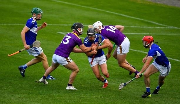 Kilkenny , Ireland - 26 June 2021; Donnchadh Hartnett of Laois prepares to clear under pressure from Wexford players Mikie Dwyer , left, and Rory...