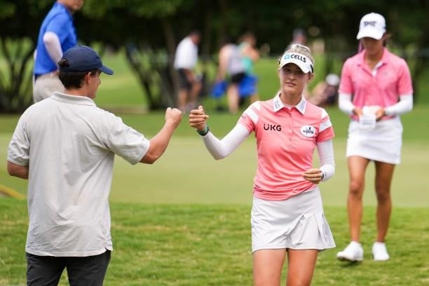 Nelly Korda fist bumps a spectator on the 15th hole during the third round for the 2021 KPMG Women's Championship at the Atlanta Athletic Club on...