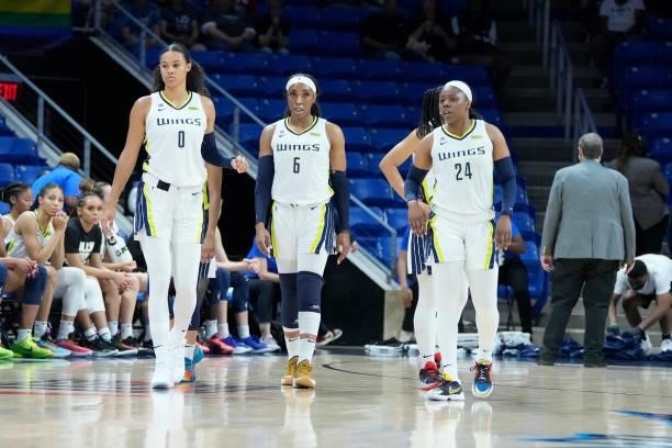 Satou Sabally, Kayla Thornton and Arike Ogunbowale of the Dallas Wings look on during the game against the Washington Mystics on June 26, 2021 at the...