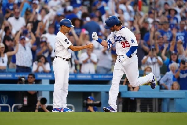 Cody Bellinger of the Los Angeles Dodgers celebrates hitting a walk-off home run with third base coach Dino Ebel during the game between the Chicago...