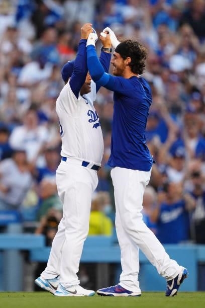 Dave Roberts of the Los Angeles Dodgers celebrates with Cody Bellinger after Bellinger hit a walk off home run during the game between the Chicago...