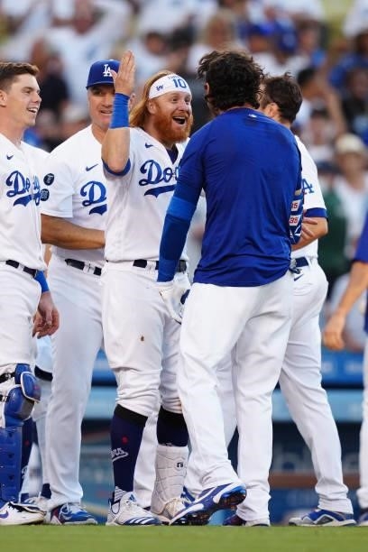Justin Turner of the Los Angeles Dodgers celebrates with Cody Bellinger after Bellinger hit a walk off home run during the game between the Chicago...