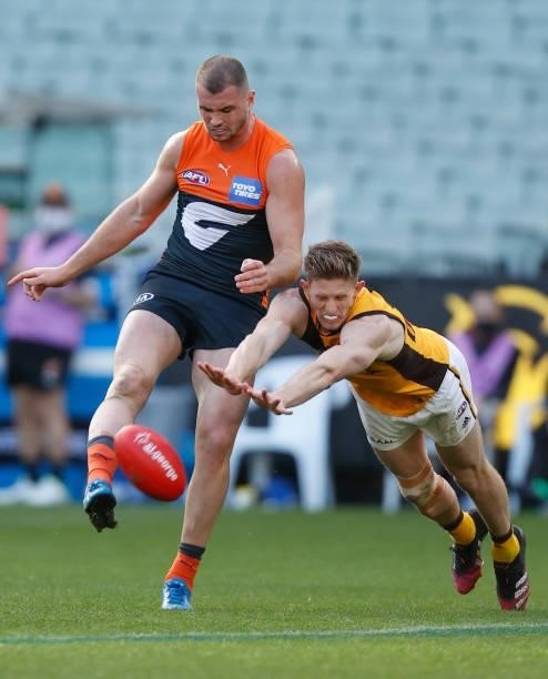Sam Frost of the Hawks attempts to smother the kick of Kieren Briggs of the Giants during the 2021 AFL Round 15 match between the GWS Giants and the...