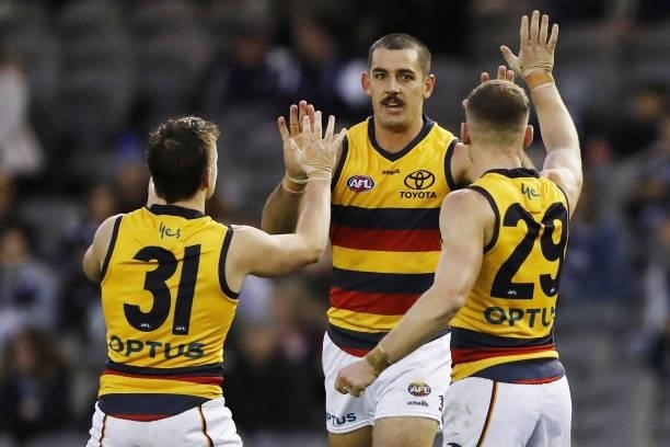 Taylor Walker of the Crows celebrates a goal with Chayce Jones of the Crows and Rory Laird of the Crows during the 2021 AFL Round 15 match between...
