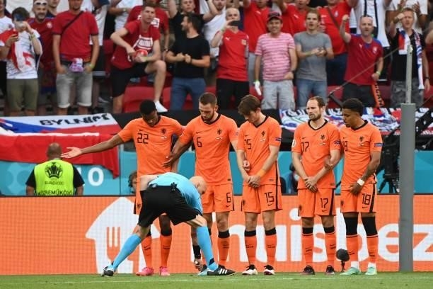 Russian referee Sergey Karasev marks the position of Netherlands' defensive wall prior to a free kick during the UEFA EURO 2020 round of 16 football...