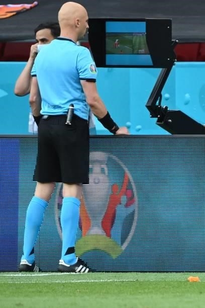 Russian referee Sergey Karasev looks at VAR footage prior to giving a red card to Netherlands' defender Matthijs de Ligt for a handball during the...