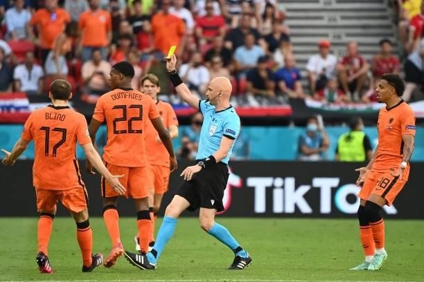 Russian referee Sergey Karasev shows a yellow card to Czech Republic's defender Vladimir Coufal for a foul on Netherlands' defender Denzel Dumfries...
