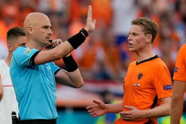 Russian referee Sergey Karasev gestures next to Netherlands' midfielder Frenkie de Jong during the UEFA EURO 2020 round of 16 football match between...