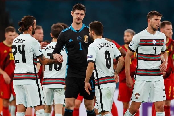 Belgium's goalkeeper Thibaut Courtois cheers Portugal's midfielder Joao Moutinho at the end of the UEFA EURO 2020 round of 16 football match between...