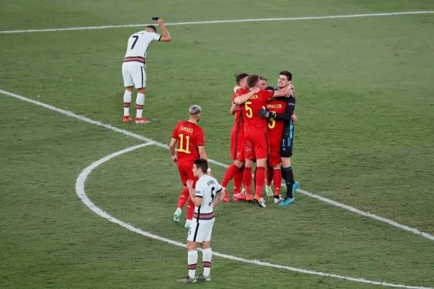 Belgium's players celebrate winning as Portugal's forward Cristiano Ronaldo reacts after the UEFA EURO 2020 round of 16 football match between...